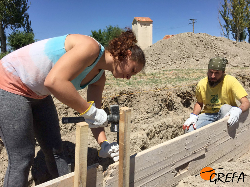 Dos voluntarios internacionales ayudan a construir una instalación con materiales ecológicos y reciclables en Villalar de los Comuneros. Foto: GREFA.