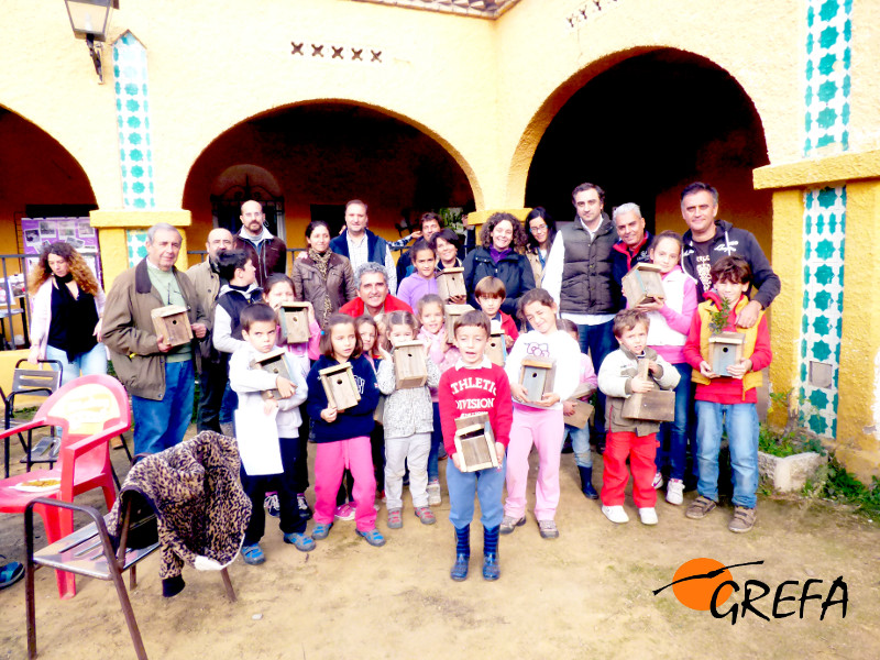 Las familias participantes en el taller de cajas nido en Trassierra (Córdoba) muestran el resultado de su participación.