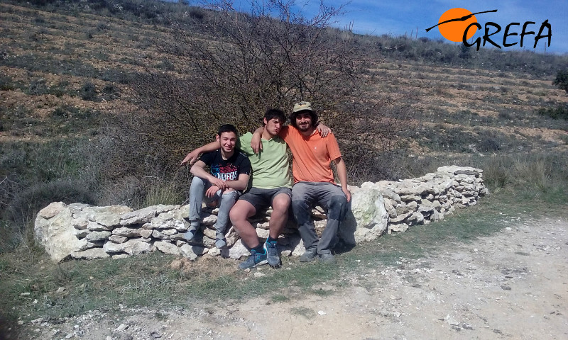 Sentados en uno de los muros de piedras, con la satisfacción del trabajo realizado.