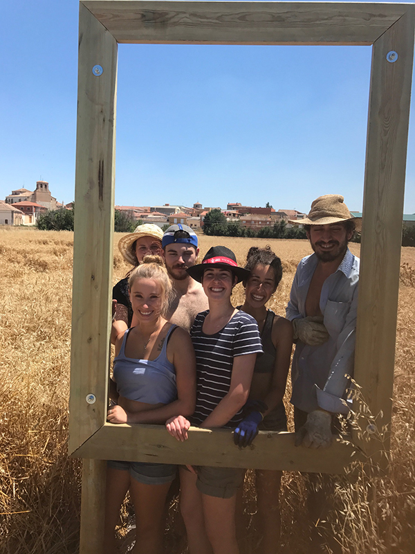 Voluntarios internacionales posan en uno de los bastidores construidos para la cartelería de la senda ambiental y cultural.