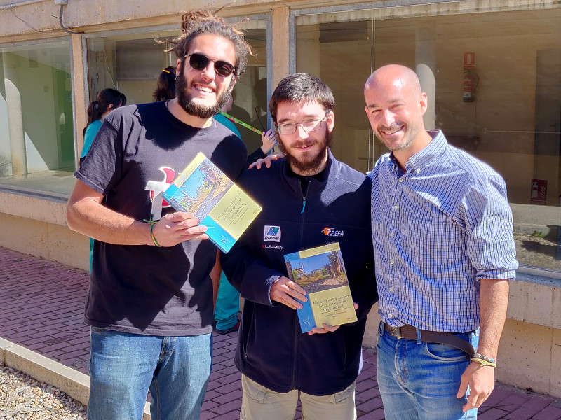 Dos alumnos del curso de técnicos de centros de recuperación, con Francisco Villaespesa. Estos alumnos muestran ejemplares del “Manual de manejo del lince ibérico en cautividad (Lynx pardinus)”, con los que fueron agraciados en un sorteo.