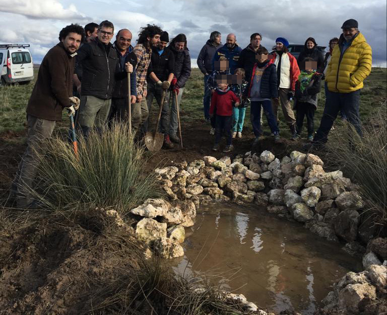 Asistentes a las jornadas agroambientales junto a la charca que construyeron para favorecer a anfibios y demás fauna silvestre.