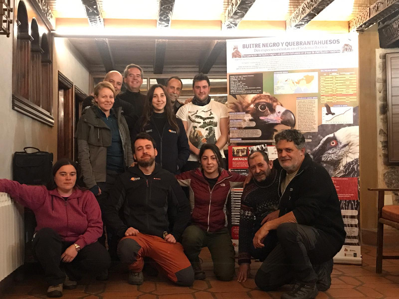 Foto de grupo del Equipo Monachus de GREFA, dedicado a la recuperación del buitre negro, junto a un cartel del proyecto.