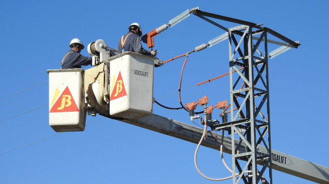 Dos operarios aíslan un apoyo eléctrico para evitar muertes de aves en una zona donde trabaja AQUILA a-LIFE.