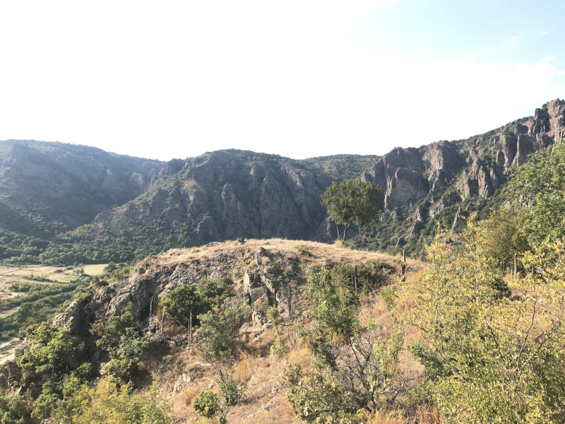 En primer plano, otra zona utilizada como comedero para aves necrófagas y al fondo, acantilados que albergan una colonia de buitre leonado, todo ello en los Montes Ródopes.