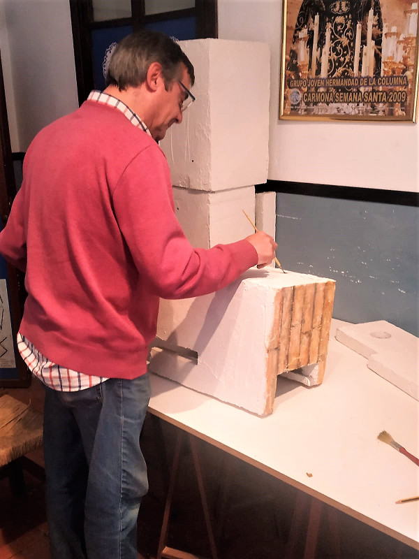 Un miembro de la hermandad de Nuestro Padre Jesús en la Columna, de Carmona, pinta una caja nido de cernícalo primilla. Foto José Antonio Peláez.