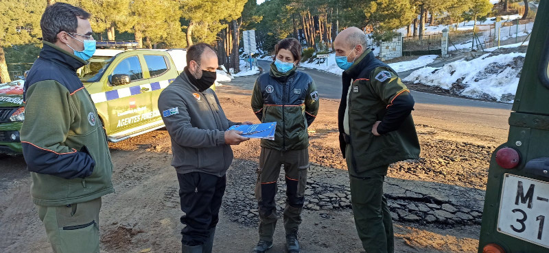 Un trabajador de GREFA entrega el Libro Blanco a varios agentes forestales de la Comunidad de Madrid.