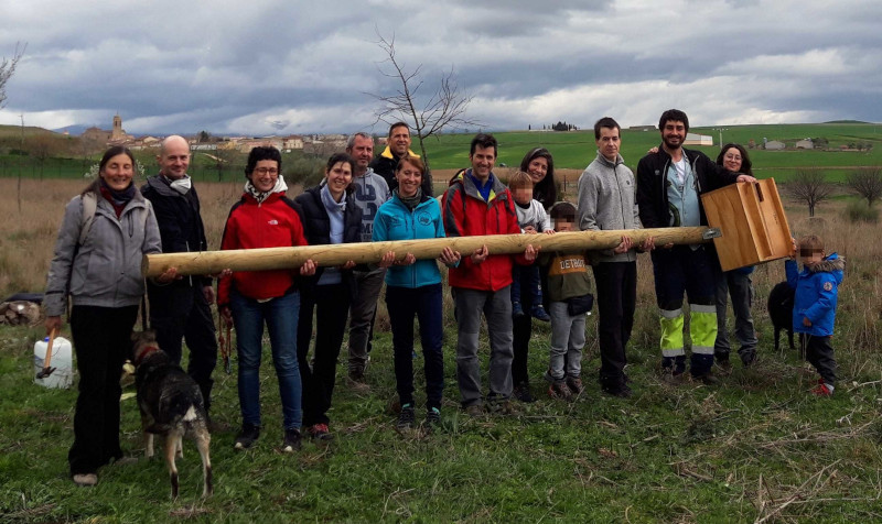 Parte de los asistentes a la jornada sujetan una caja nido para lechuzas de GREFA antes de su instalación.