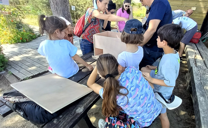 Un grupo de voluntarios construye las cajas nido para las lechuzas.