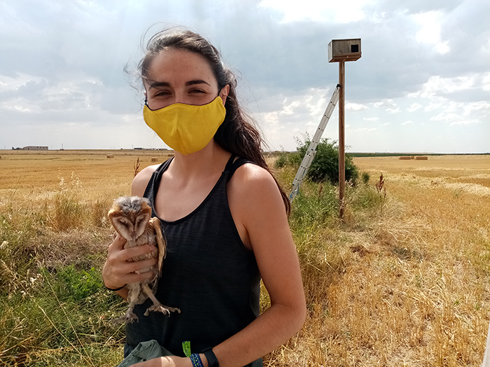 Voluntaria de GREFA con un pollo de lechuza.