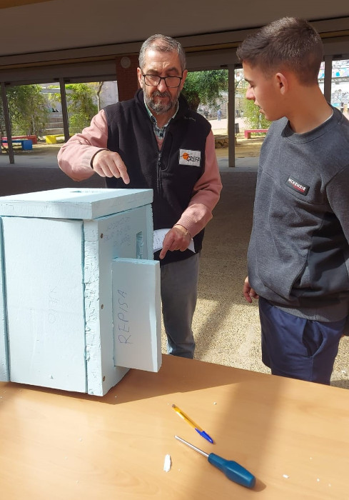 Nuestro compañero de GREFA en Carmona explica el ensamblaje de una caja nido a uno de los alumnos. Foto: Olga Santamaría.