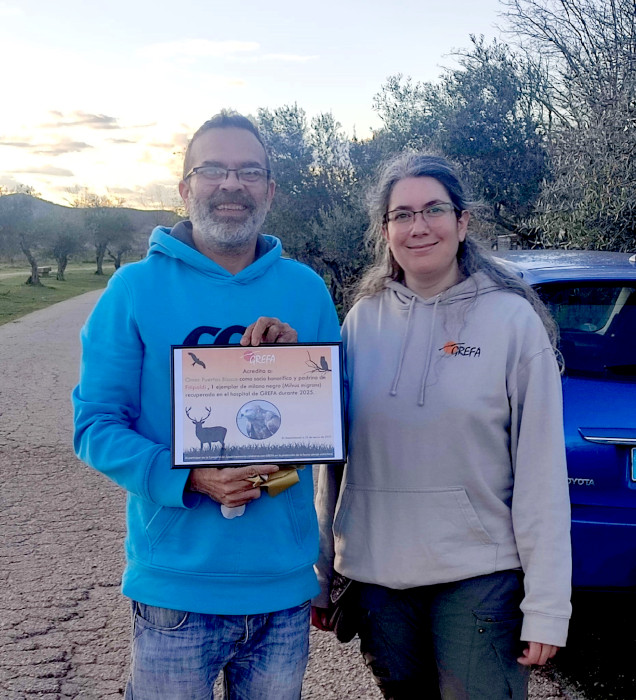 Omar, con el diploma que le acredita como padrino del milano negro “Fitipaldi”, junto a nuestra compañera Carolina Esteban, del Equipo de Rescate de GREFA.